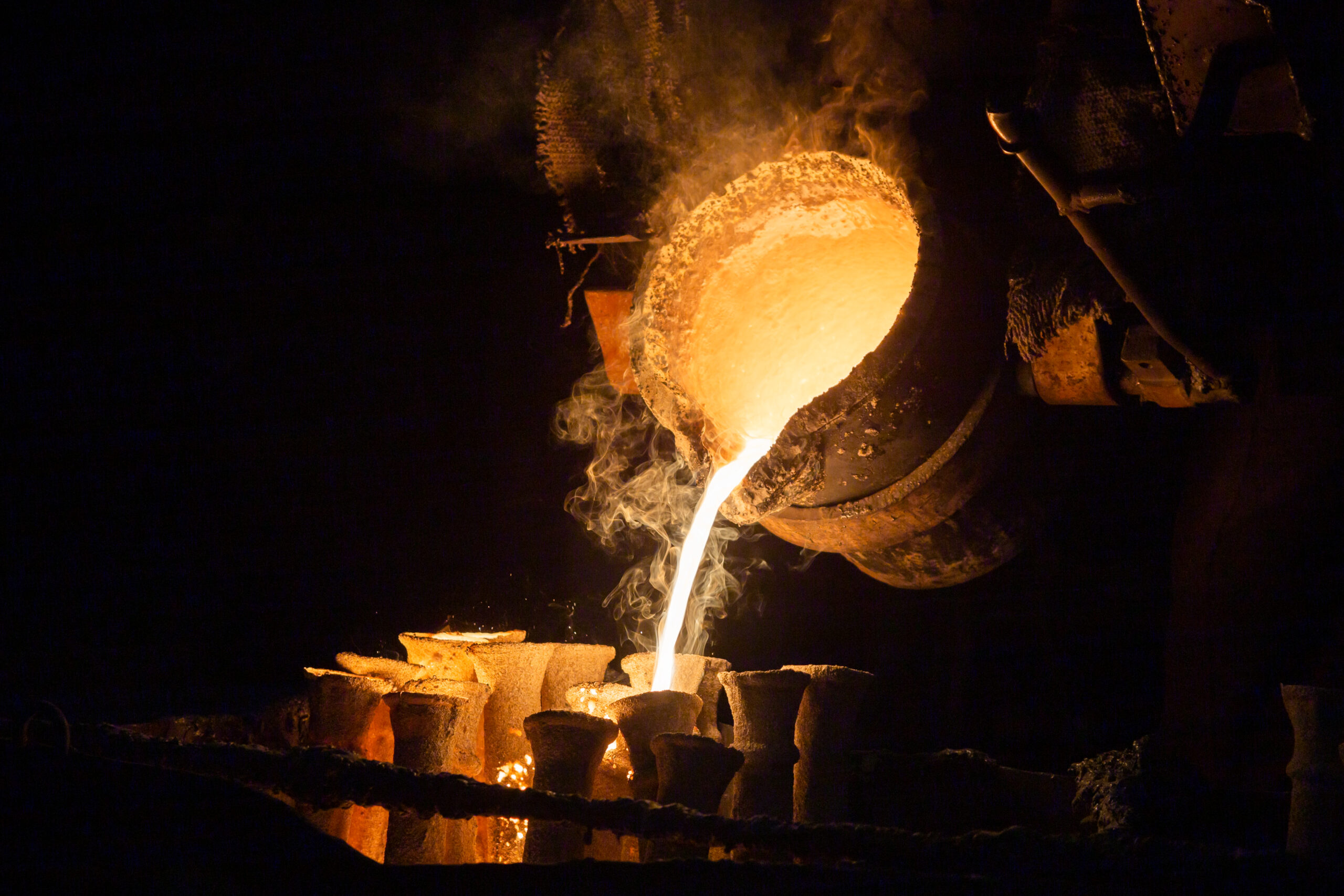 Industrial lost wax casting. The process of pouring for filling out ceramic shells with molten steel from ladle.