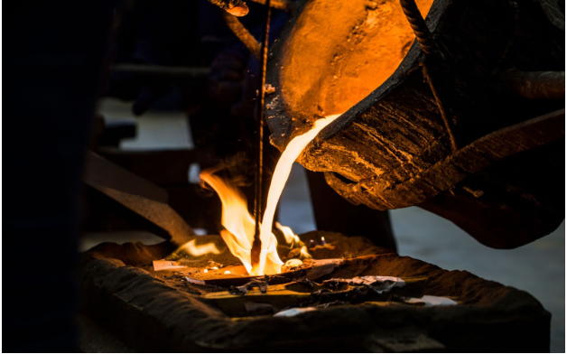 Molten metal being poured into a mold during the investment casting process.