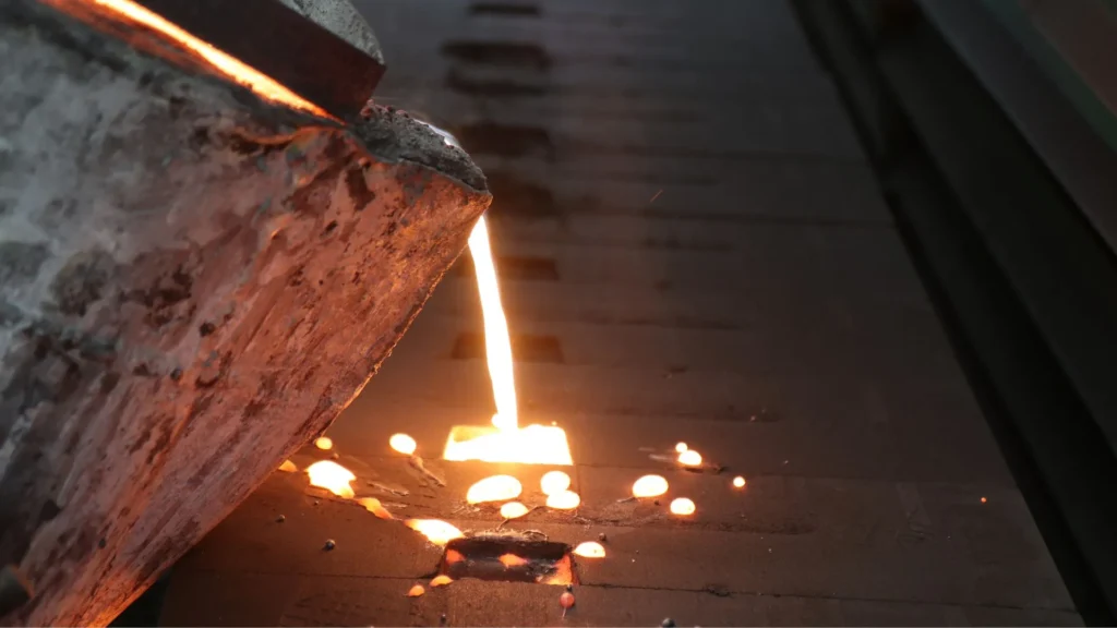 Molten metal being poured from a crucible into a mold during the casting process.