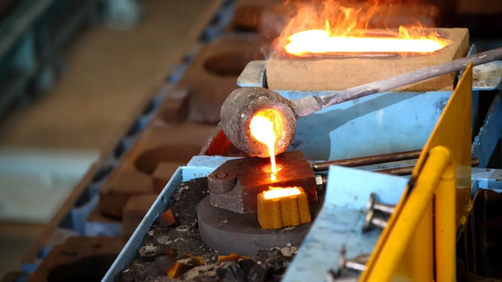 Molten metal being poured into a small mold for precision casting in a controlled setup.