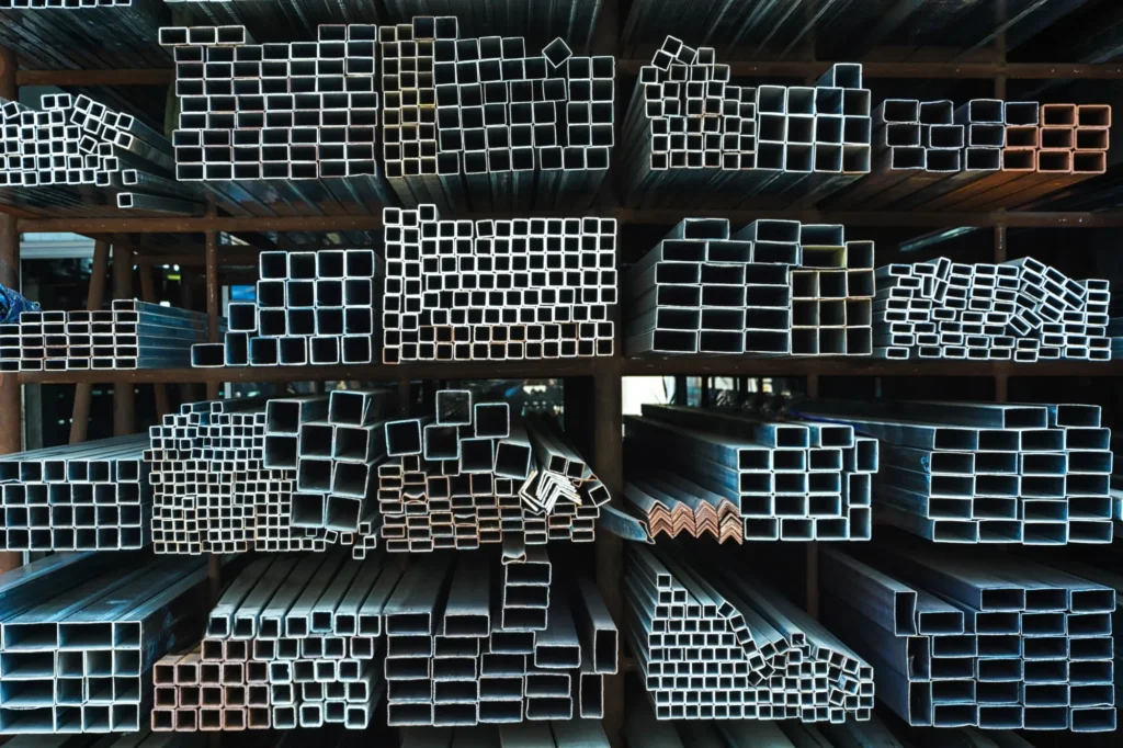 Organized stack of metal tubes in various shapes and sizes, representing storage for industrial use.